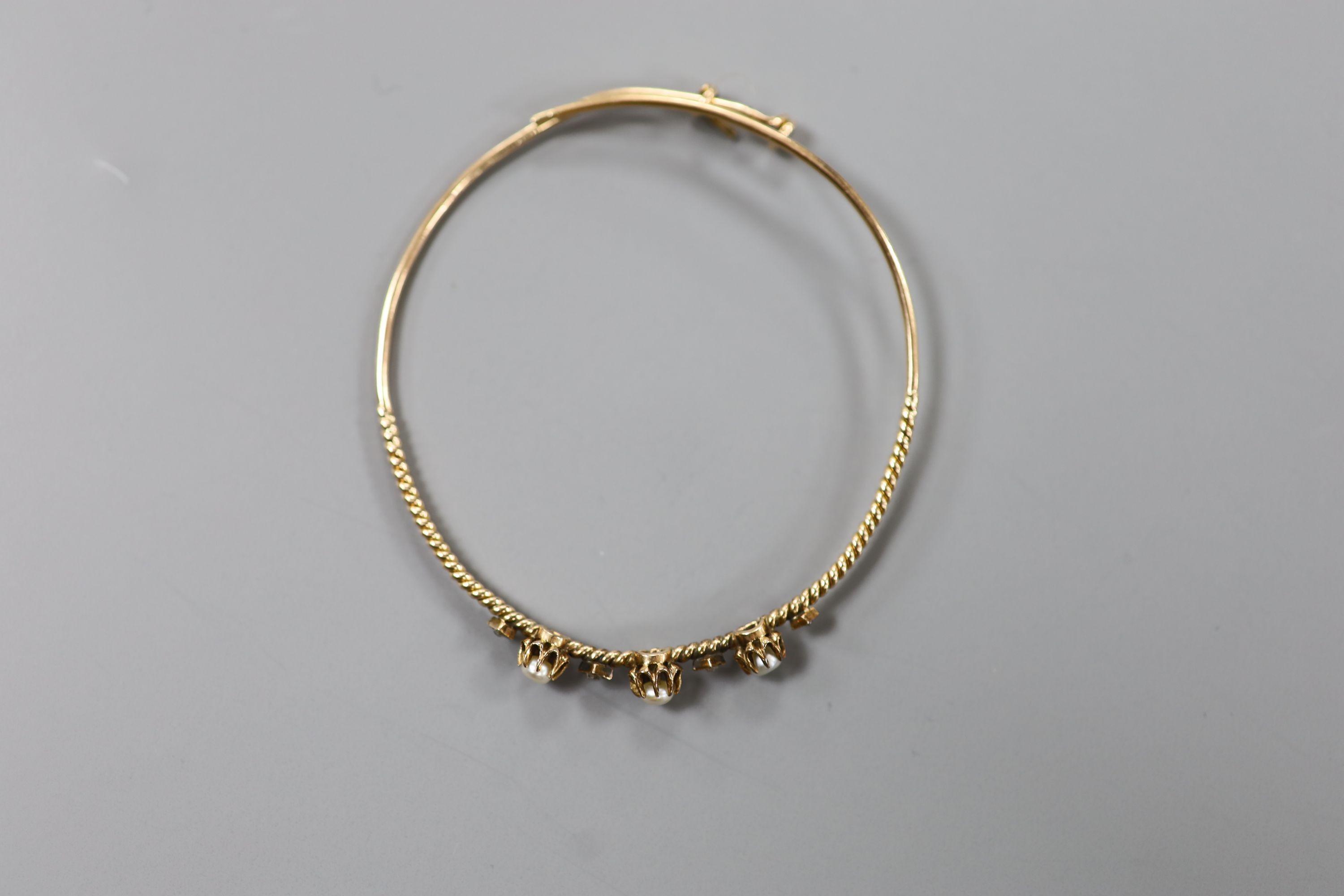 An antique yellow metal, rose cut diamond and pearl(untested) set bangle, gross weight 6.5 grams.